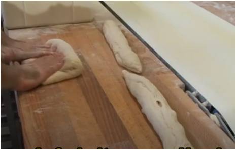Ročno oblikovanje Baguetta na priročni mizi, ob izhodnem traku stroja TWIN DIVIDER